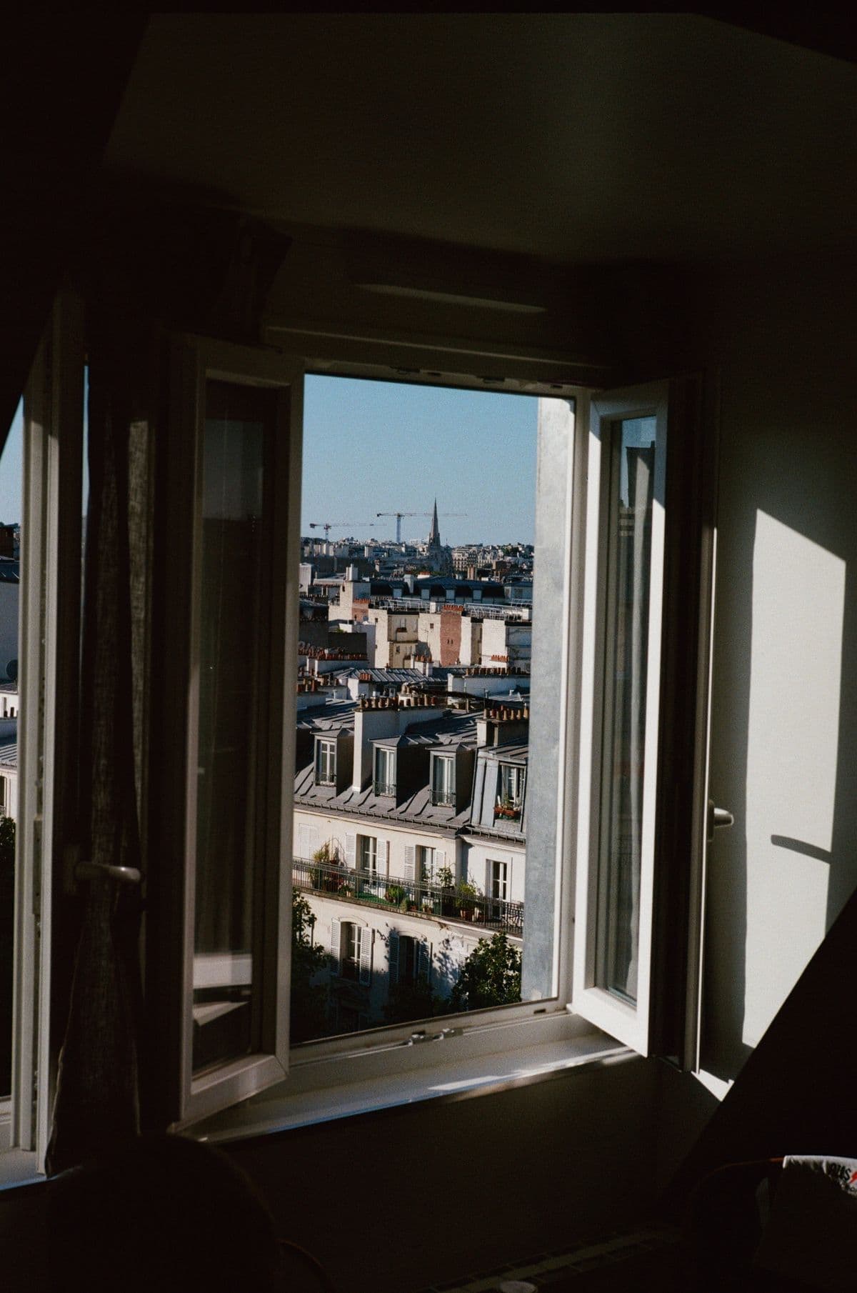 Vue sur les toits de Paris depuis une fenêtre d’appartement